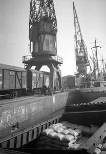 854049 Afbeelding van goederenwagens op een kade in de haven van Rotterdam.